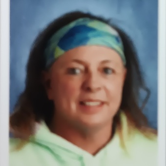 Scanned photo of Terri Allan, long dark hair, blue green patterned headband, smiling